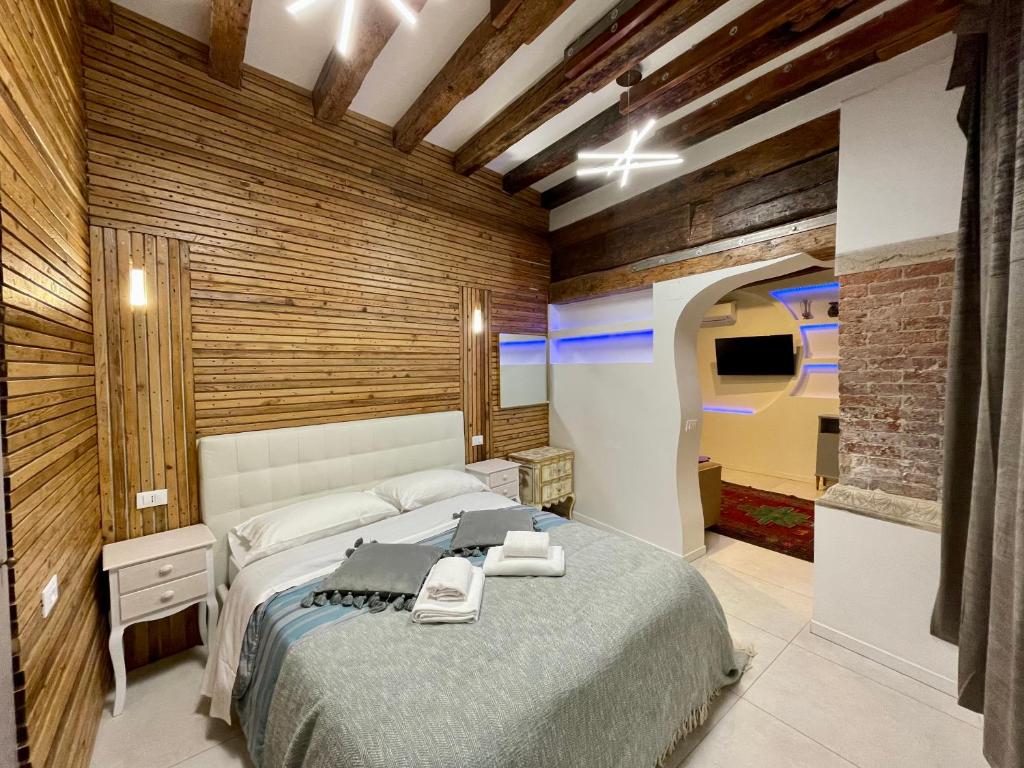 um quarto com uma cama grande e paredes de madeira em Hayez Rooms em Veneza