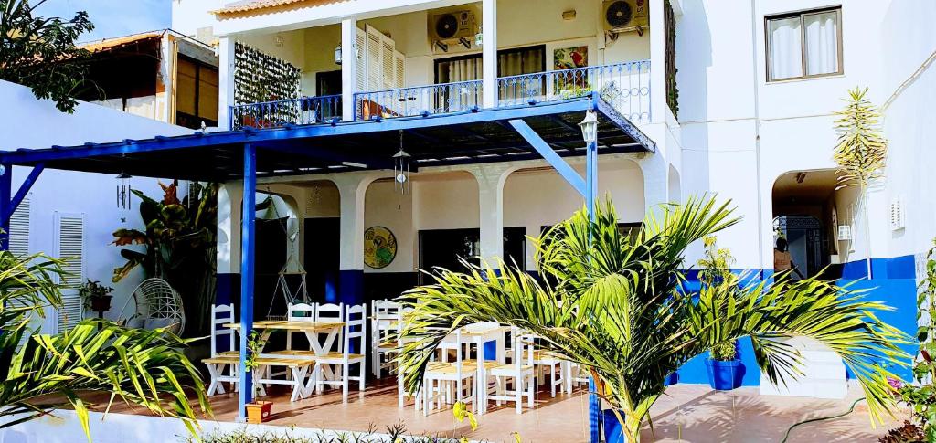 un edificio con balcone arredato con tavoli e sedie di Kelly Guest House a Praia