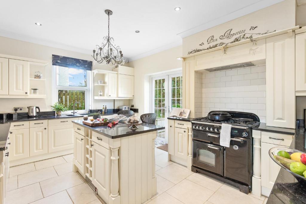 een keuken met witte kasten en een fornuis met oven bij Family Home By The Sea in Torquay