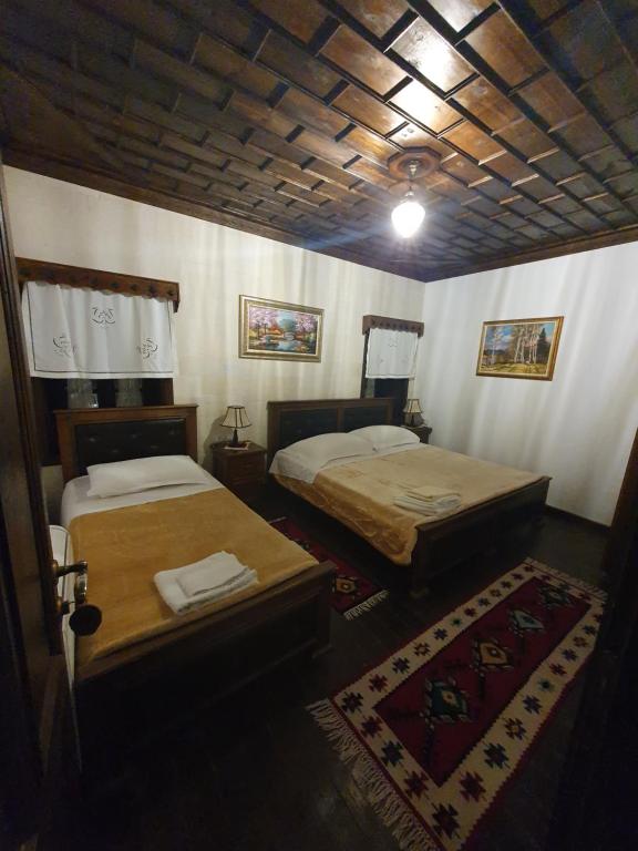 a room with two beds in a room with a rug at Hotel Klea in Berat