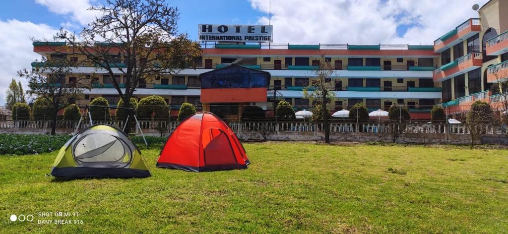 two tents sitting in the grass in front of a hotel at Hotel International Prestige in Ambato