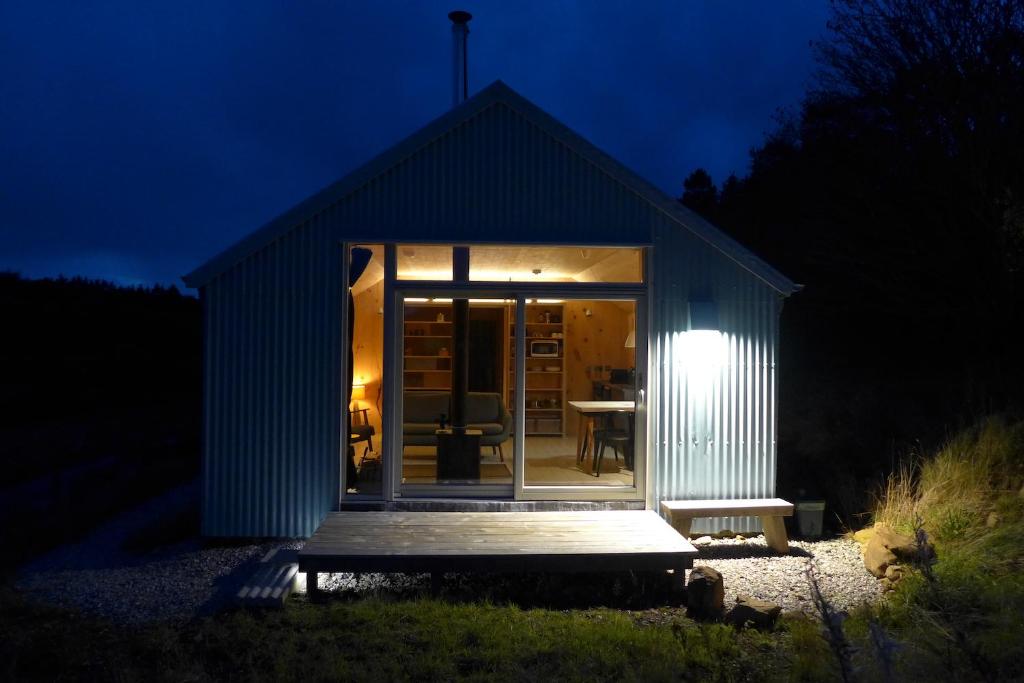 a small shed with a porch at night at The Tin Church in Port na Long