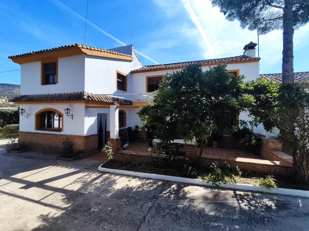 una casa blanca y naranja con árboles delante de ella en Paredejas del Rey en Priego de Córdoba