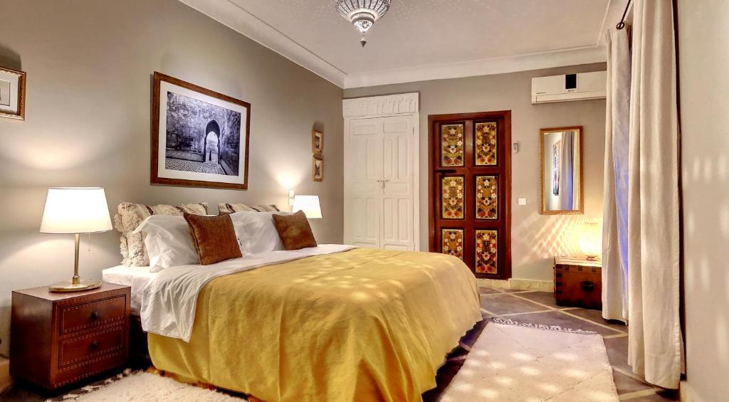 1 dormitorio con 1 cama grande con manta amarilla en Riad Dar Chacha en Marrakech