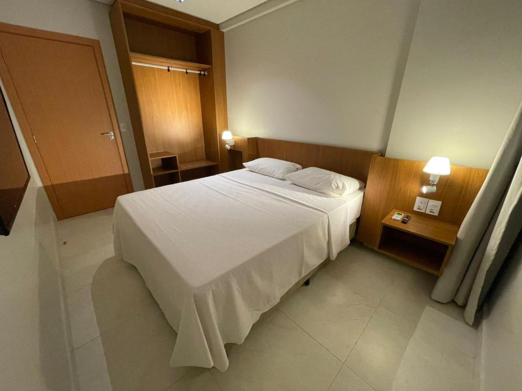 1 dormitorio con 1 cama blanca grande y 2 almohadas en Salinas Exclusive Resort en Salinópolis