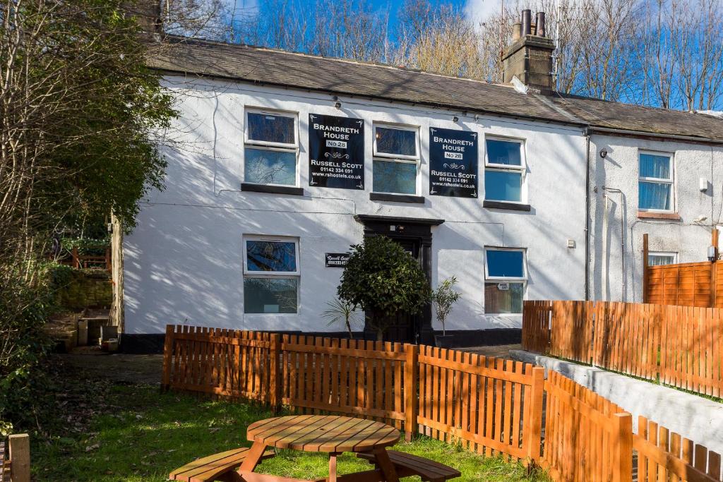 a white building with a wooden fence in front of it at Russell Scott Backpackers - Sheffield in Sheffield