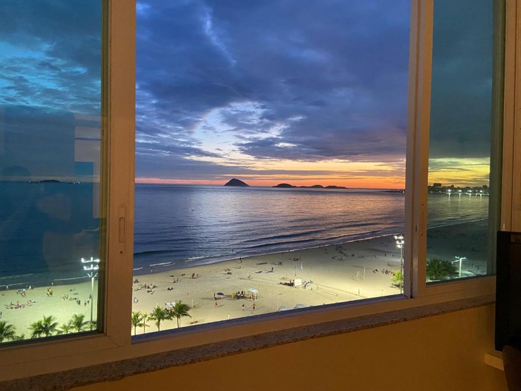 a view of a beach from a window at Apto. Leme 10º andar frente para o mar (vista espetacular) in Rio de Janeiro