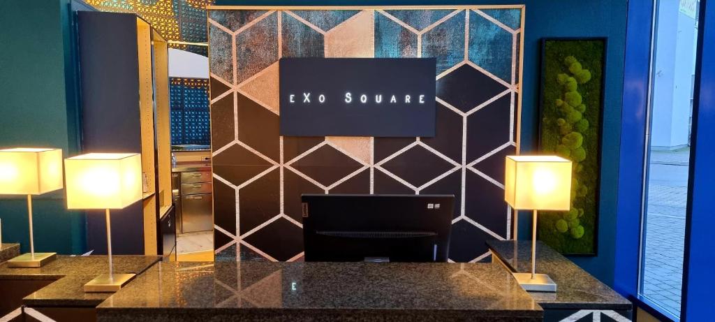 um átrio com uma recepção com duas lâmpadas em eXo Square Heidelberg/Schwetzingen - by SuperFly Hotels em Schwetzingen