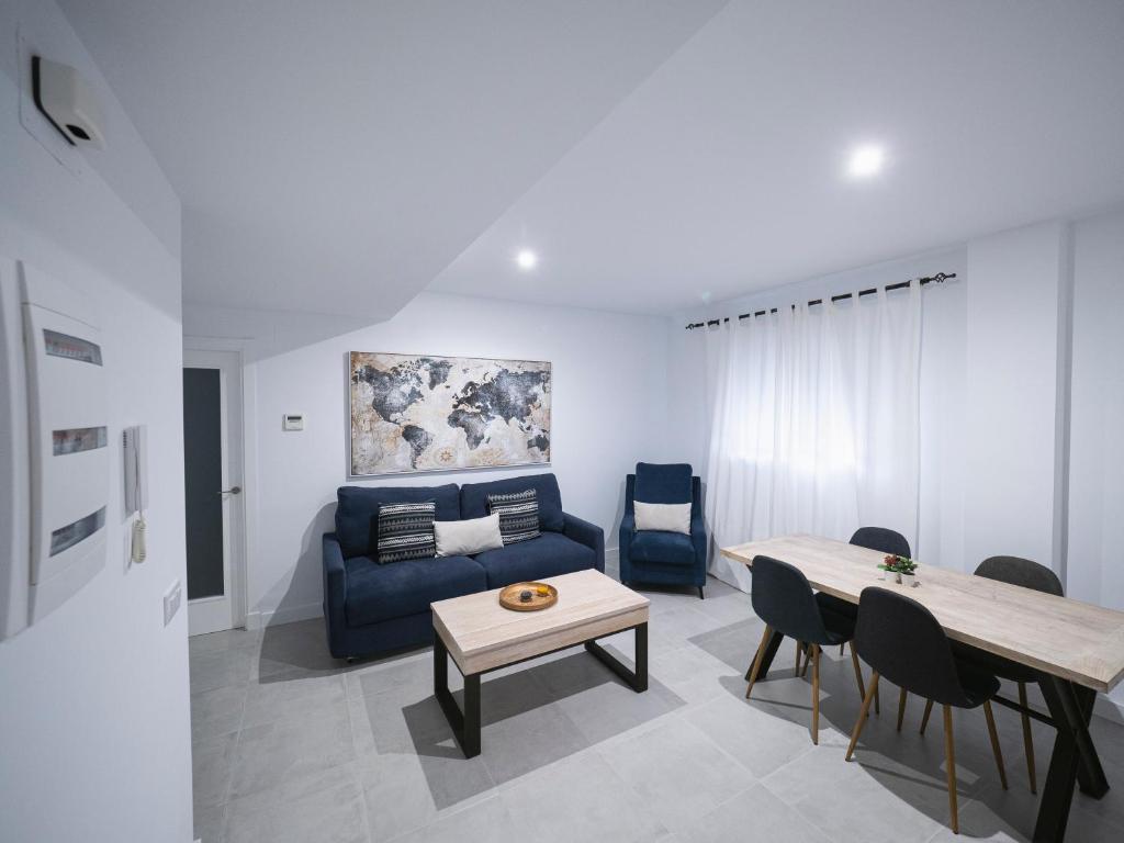 een woonkamer met een blauwe bank en een tafel bij Jardin Luxury fjHomefj in Jerez de la Frontera