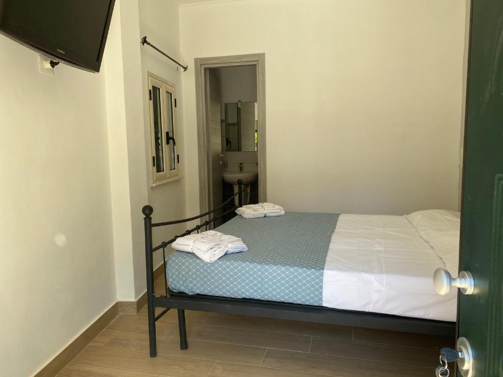 ein Schlafzimmer mit einem Bett und ein Badezimmer mit einem Waschbecken in der Unterkunft Stanza per 2 persone da Antonio in Parghelia