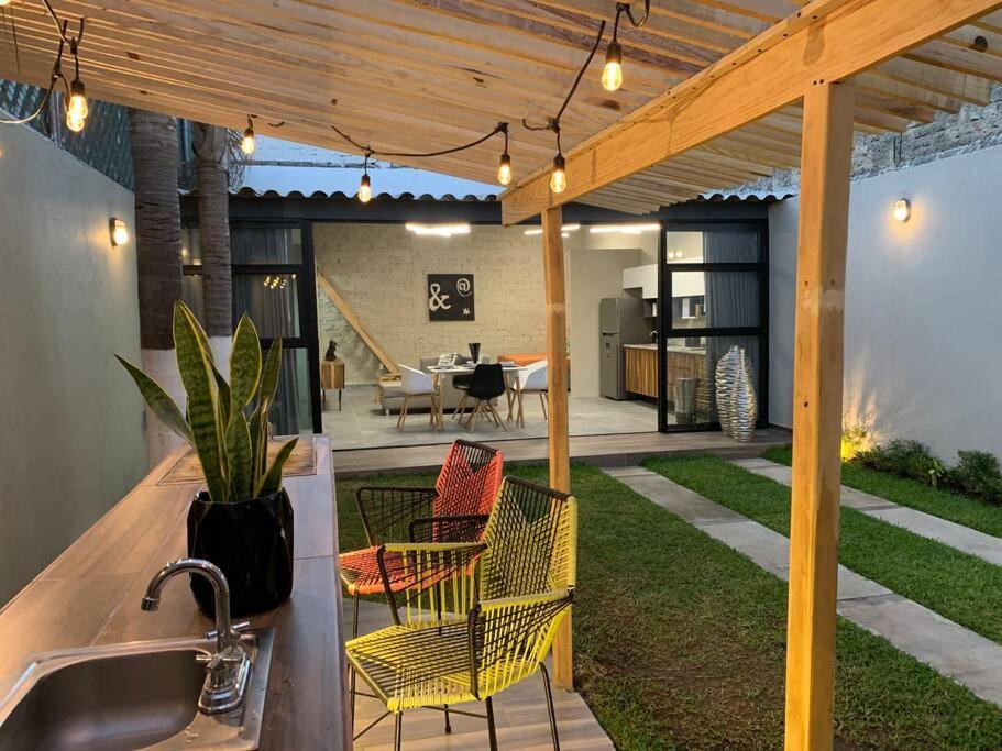 a patio with a sink and chairs under a pergola at Begonias Loft cerca del Auditorio Telmex! in Guadalajara