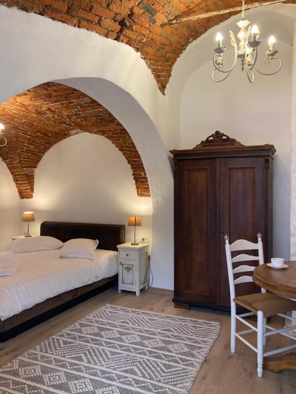 a bedroom with a bed and a table with a chair at Historical Center Residence 2 in Sibiu
