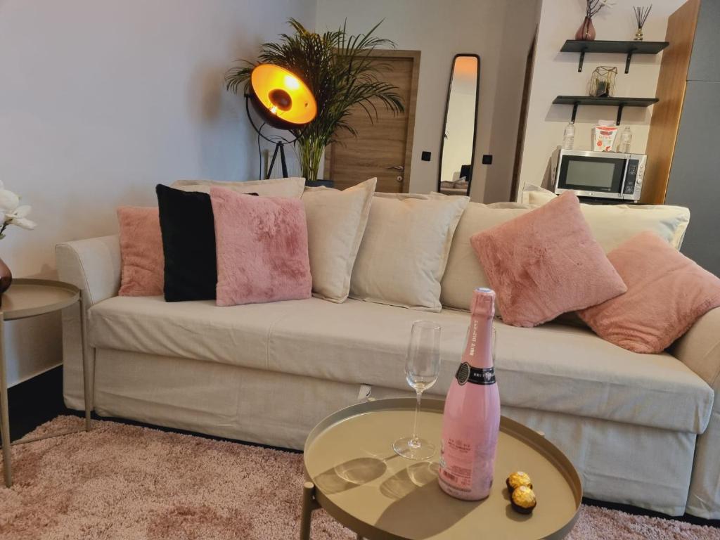 Sala de estar con sofá blanco y botella de champán en La suite de lati en Lieja
