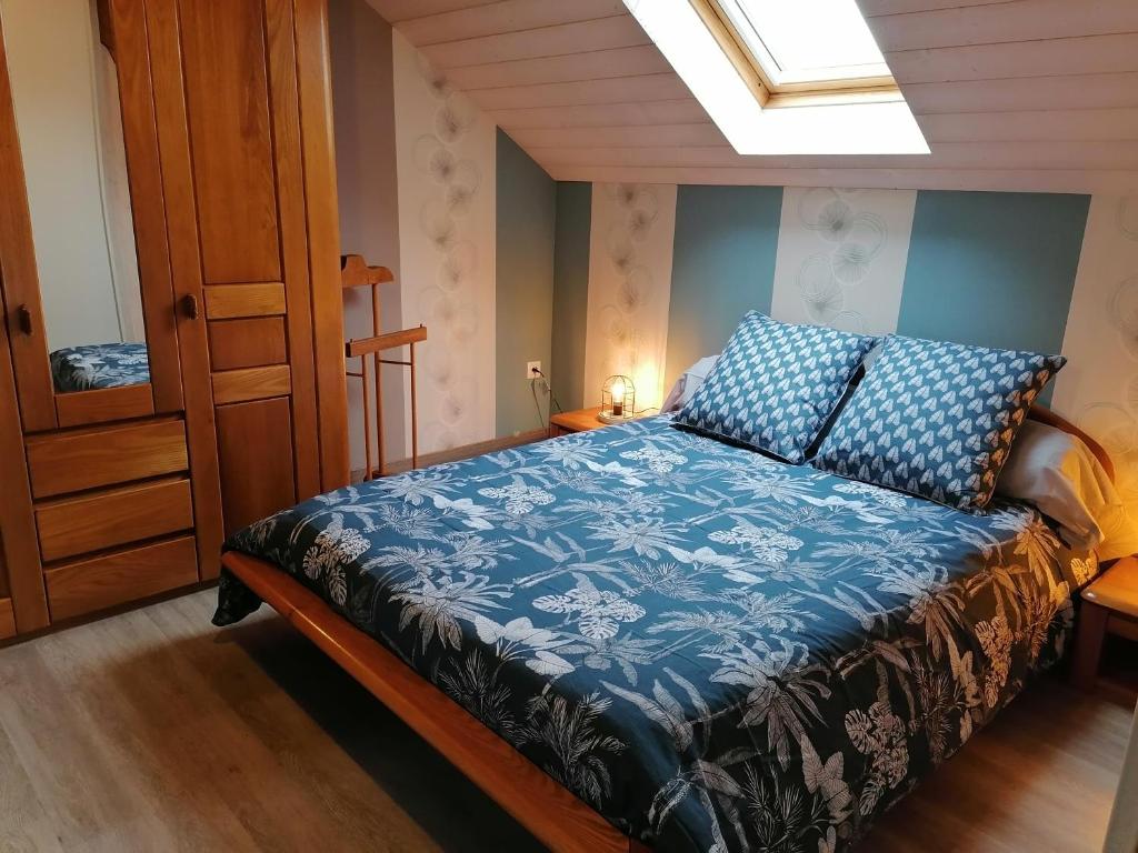 1 dormitorio con 1 cama con edredón azul en Grand Studio Entre Saône et Vignes, en Tréclun