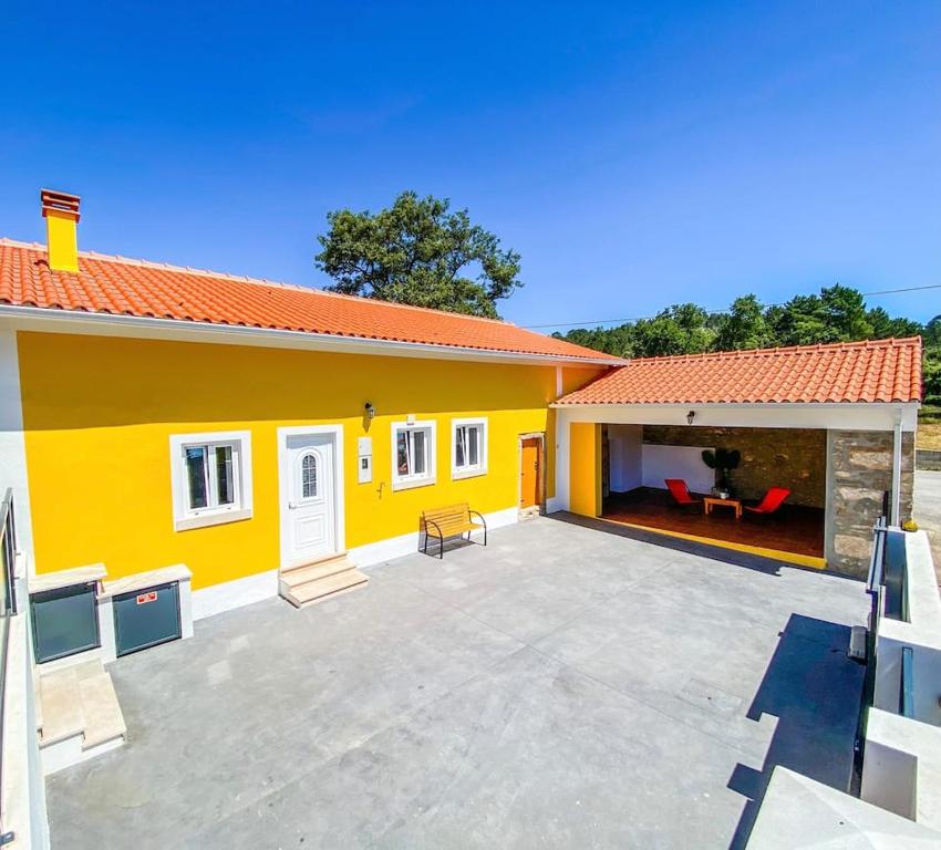 a yellow house with a large patio in front of it at Casa da Avó 