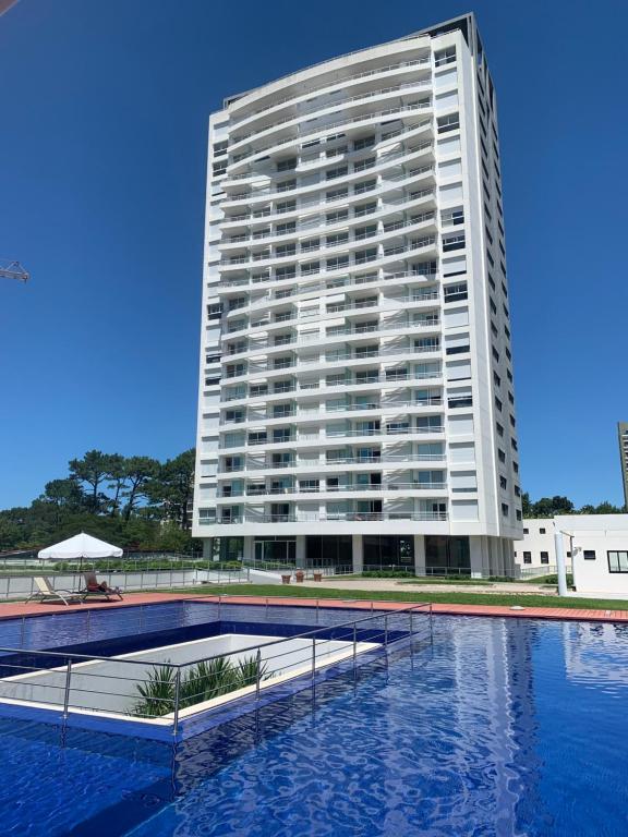 a large white building with a pool in front of it at Green Life Full Amenities in Punta del Este