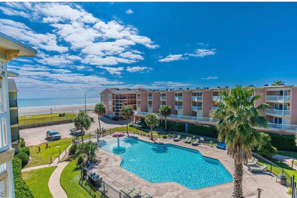an aerial view of a resort with a swimming pool and the beach at Beach Escape - Top floor Ocean views - Heated pool - Seawall Blvd in Galveston