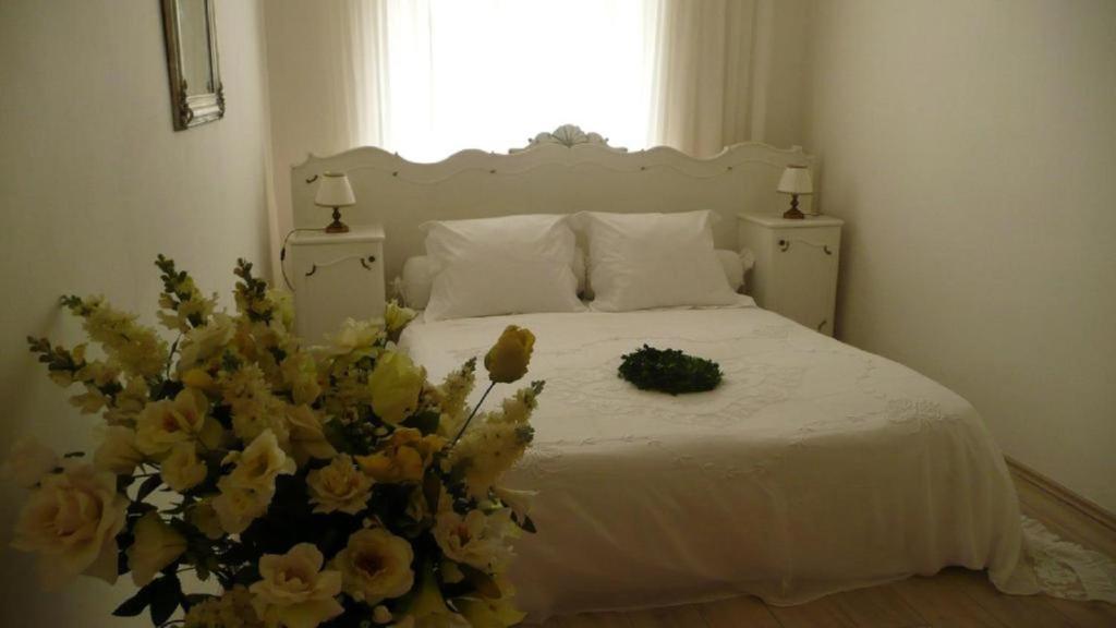 een slaapkamer met een wit bed en een boeket bloemen bij Apartment Dům U Černého beránka in Praag