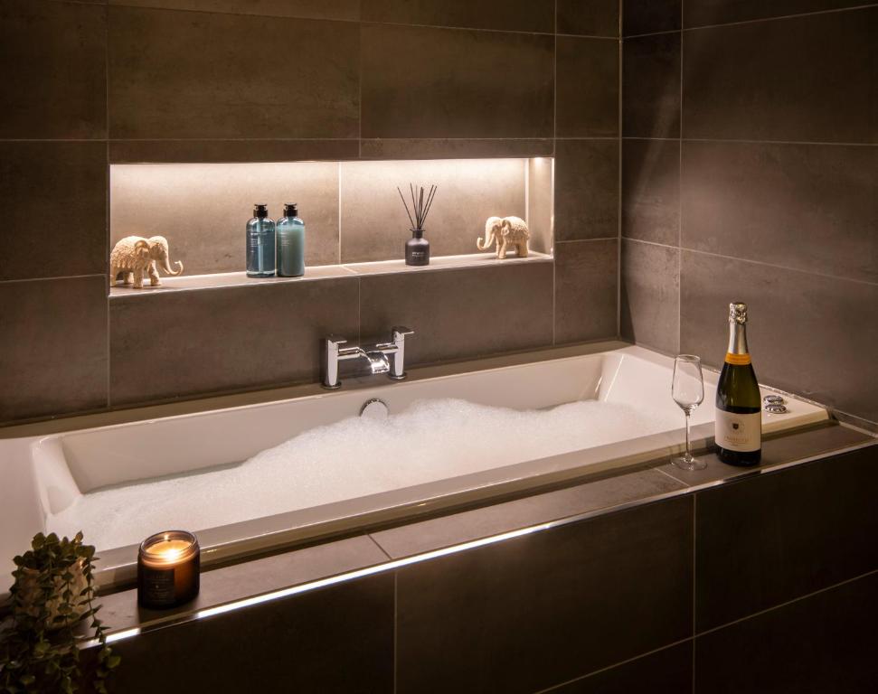 a bathroom with a bath tub with a bottle of wine at Station View, Dunblane in Dunblane