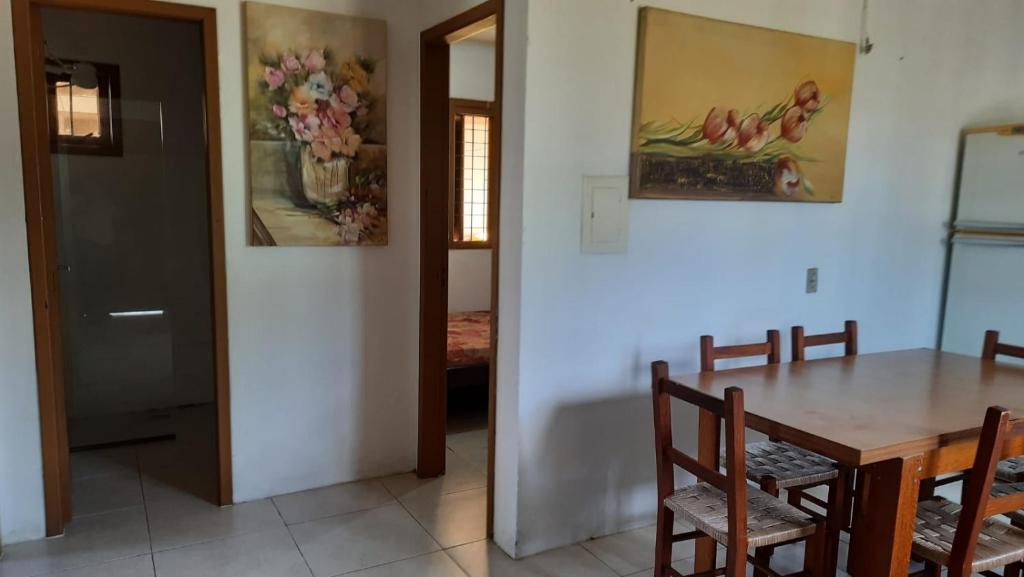 a kitchen and dining room with a table and chairs at Casa Residencial Duque de Caxias in Arroio do Sal