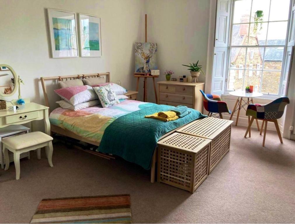 a bedroom with a bed and a table and chairs at Spacious and cozy apartment in the heart of Haddington in Haddington