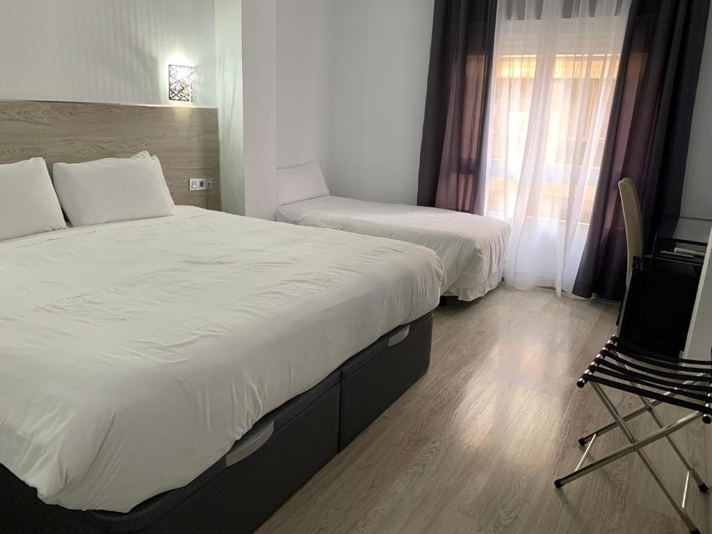 Postel nebo postele na pokoji v ubytování Hotel Carlos III