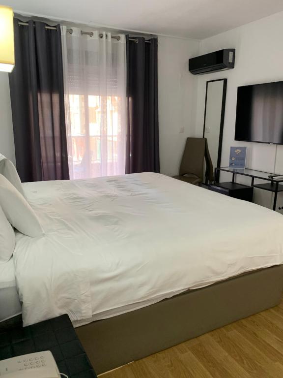 a large white bed in a room with a window at Hotel Carlos III in Águilas