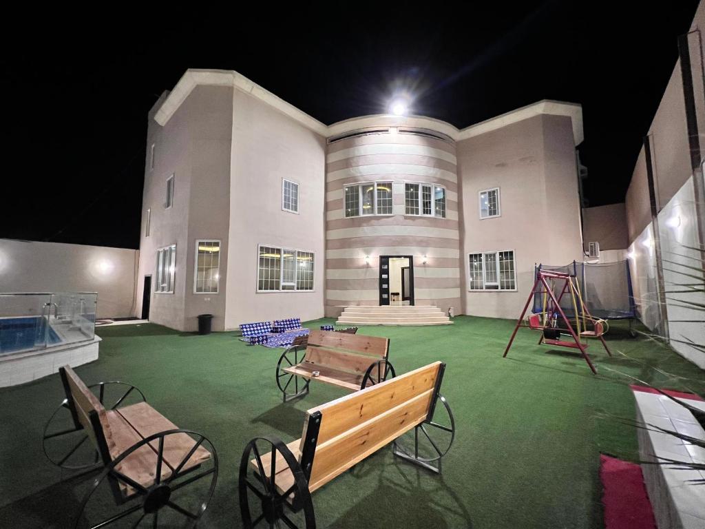 a building with benches and a playground in front of it at فيلا كارمة in Al Madinah