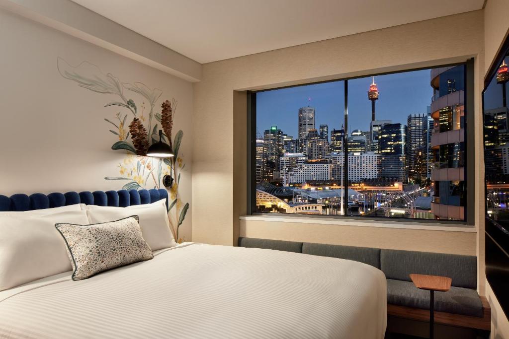 a bedroom with a large window with a city view at Aiden by Best Western Darling Harbour in Sydney