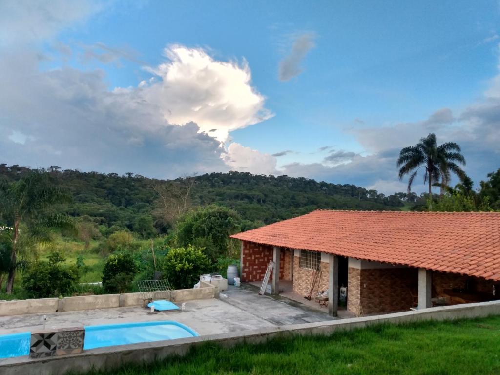 a villa with a swimming pool and a house at Chácara Terra Boa in Extrema