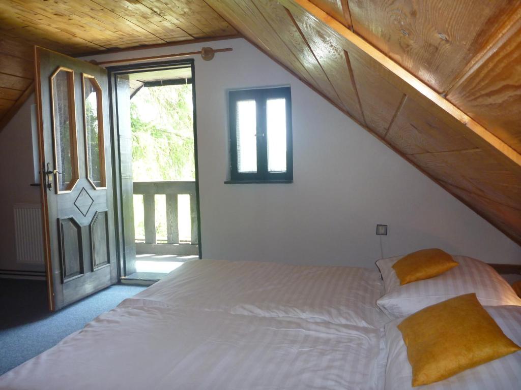 a bedroom with a white bed with a large window at Penzion Olšina 31 in Horní Planá