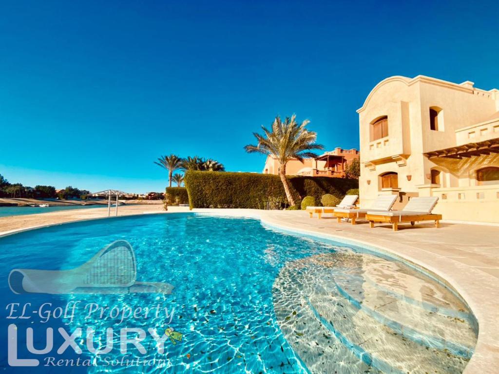 a swimming pool in front of a house at Private Villa Y51 - 3 BedRooms at El-Gouna in Hurghada