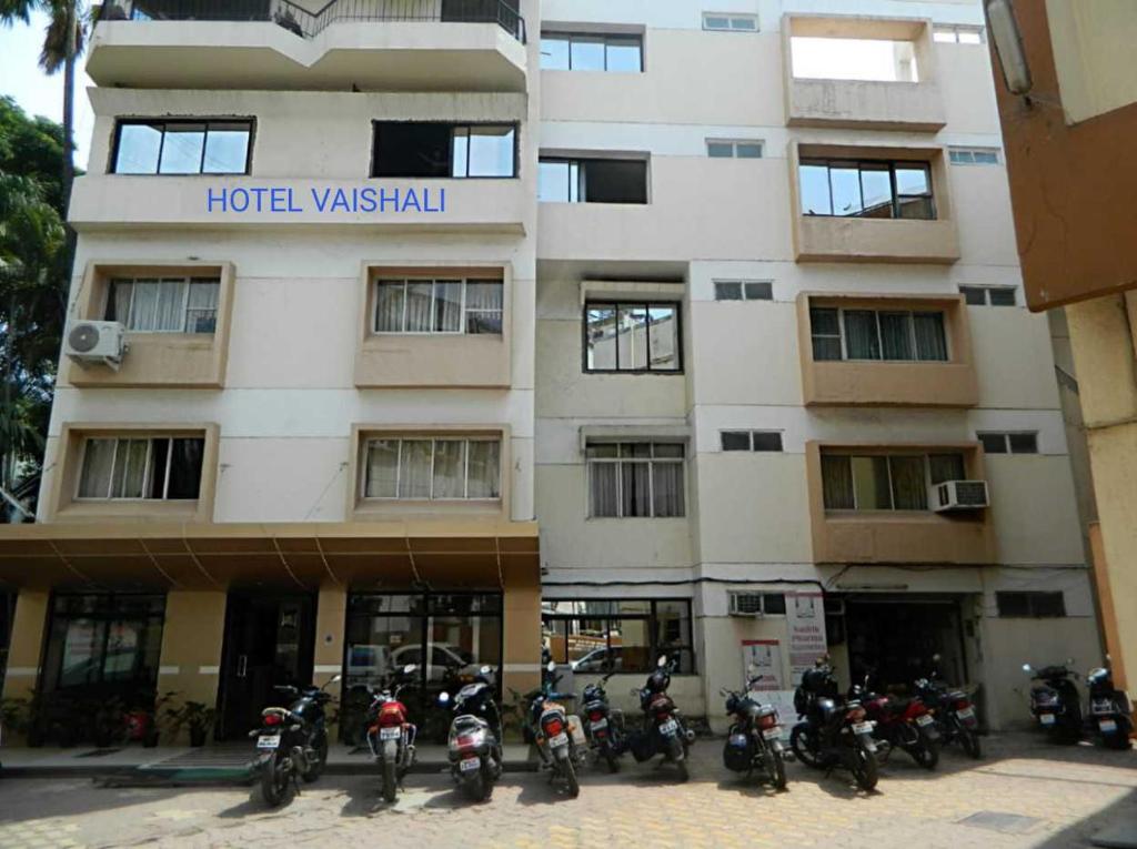 un grupo de motocicletas estacionadas frente a un edificio en Hotel Vaishali, en Nashik