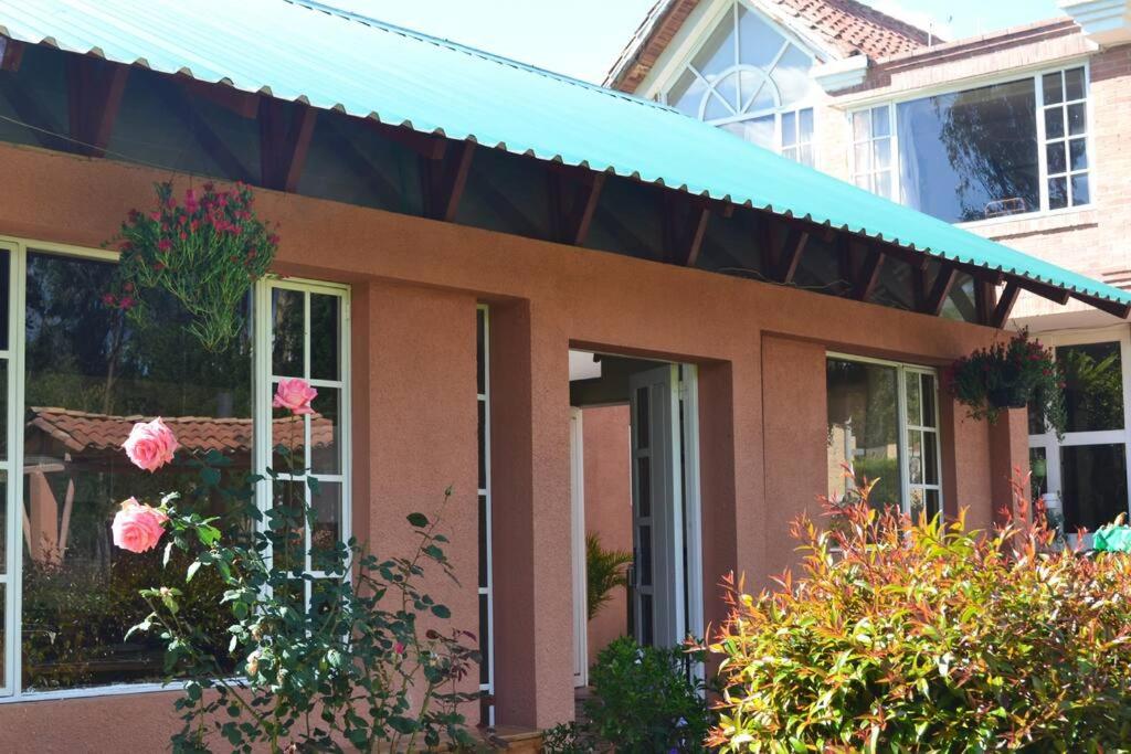 una casa marrone con un tendone blu sopra di "Confortable Cabaña entre Paipa y Duitama" a Duitama