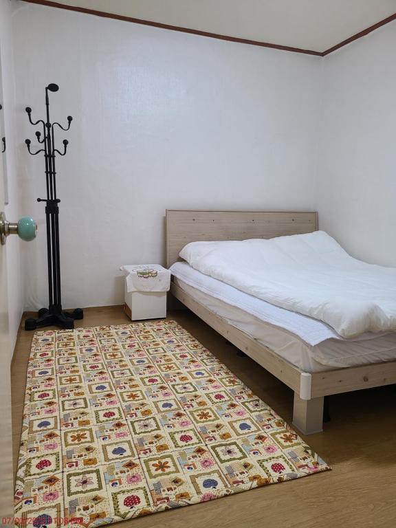 a bedroom with a bed and a rug at Chenal Motel in Daegu
