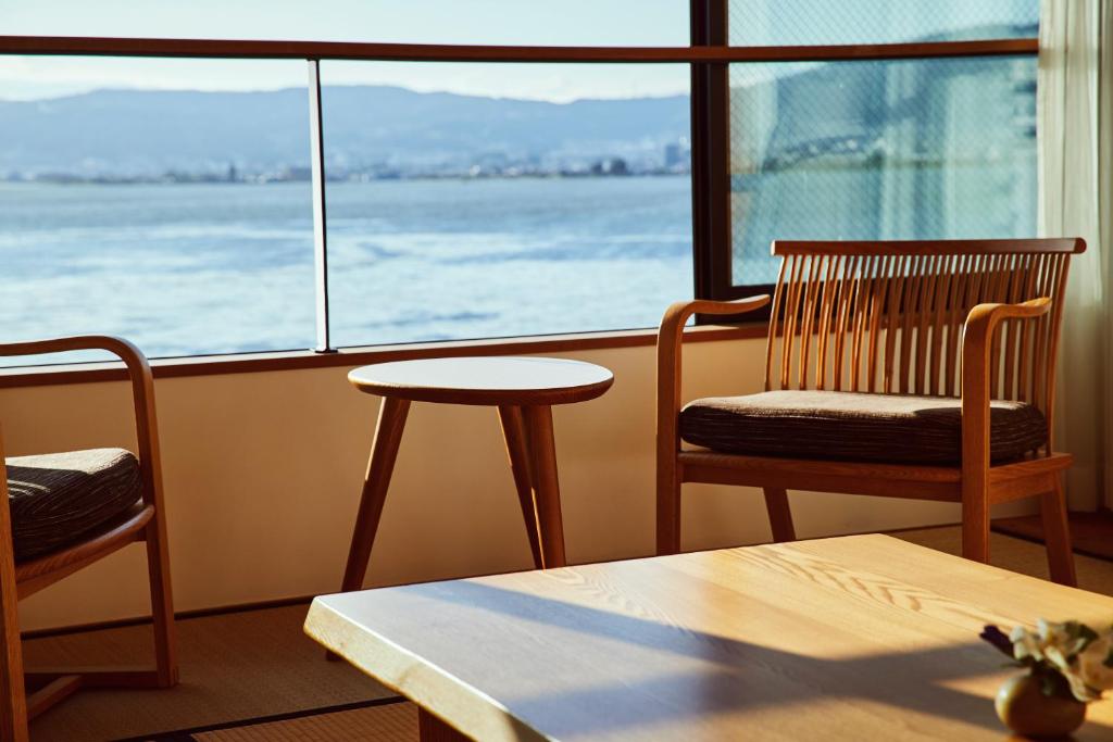 a room with two chairs and a table and a window at Sui Suwako in Suwa