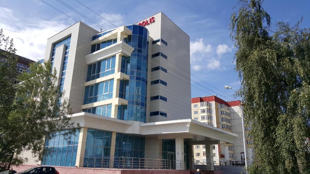 a large building with glass windows in a city at Hotel Metropolis in Surgut