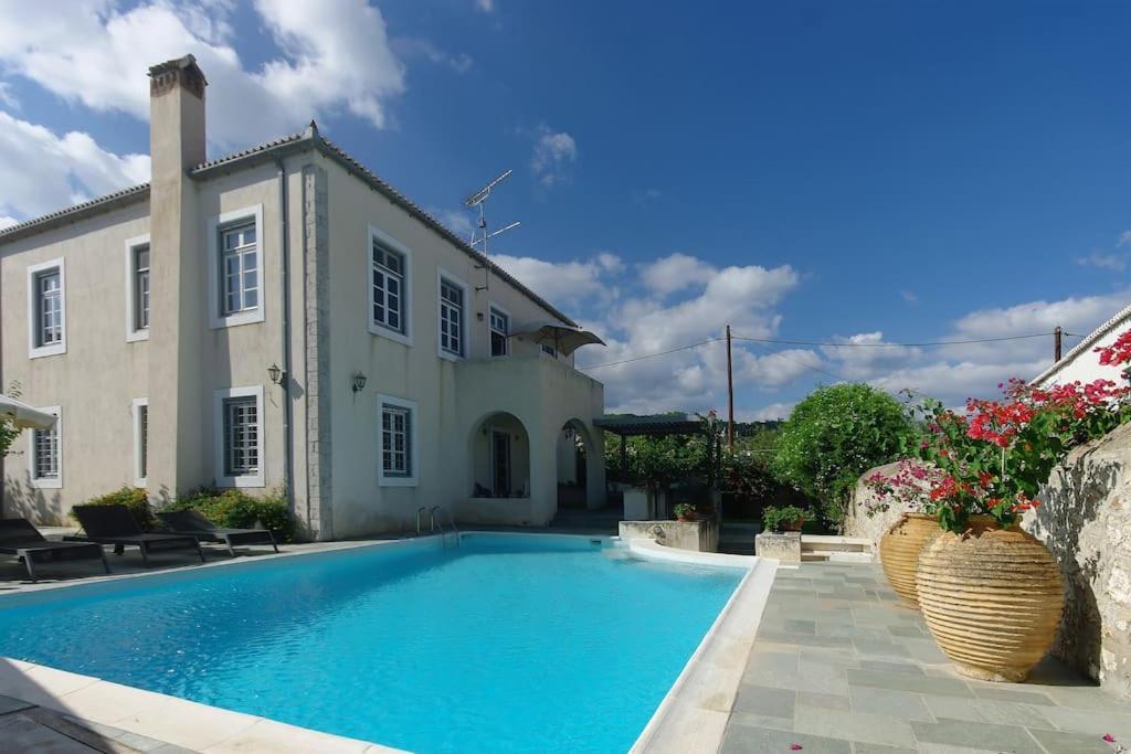 a swimming pool in front of a house at Villa 1853, Spetses Ground Floor in Spetses