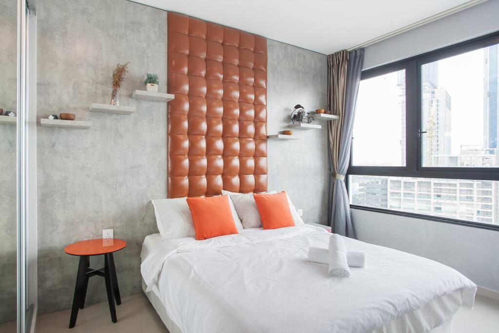 ein Schlafzimmer mit einem großen Bett mit einem orangefarbenen Kopfteil in der Unterkunft iCity 1Bedroom Apt Near Mall FREE PARKING & WIFI in Shah Alam