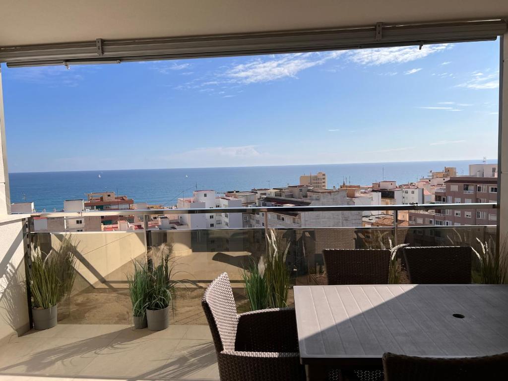 a balcony with a table and a view of the ocean at Sol y Mar in El Campello