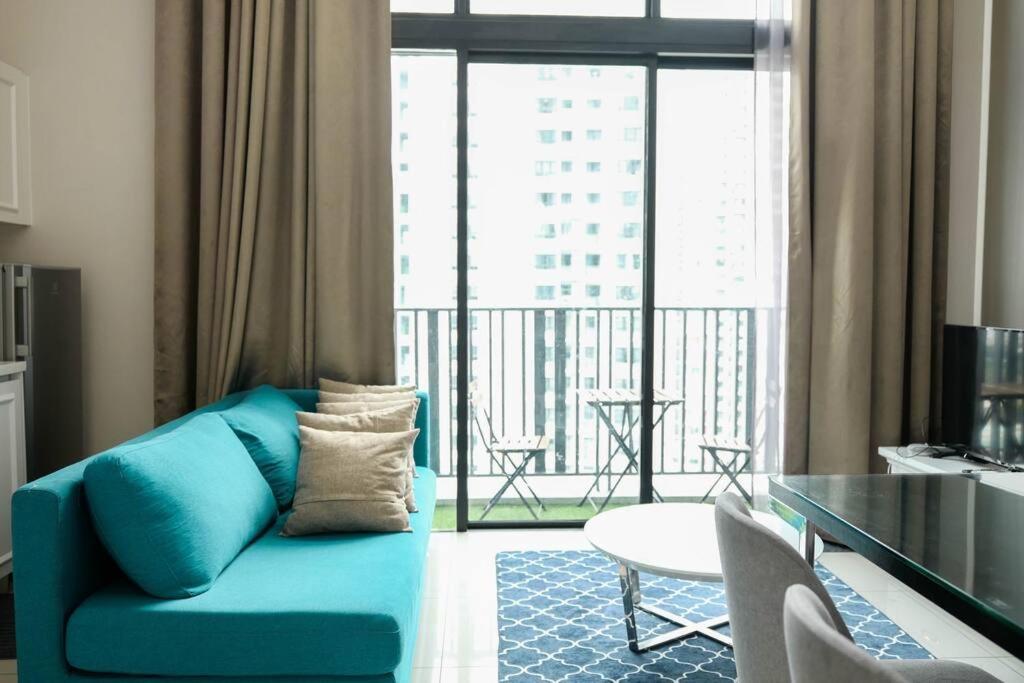 een woonkamer met een blauwe bank en een balkon bij Luxury Penthouse iCity Near Mall & Themepark FREE PARKING WIFI in Shah Alam