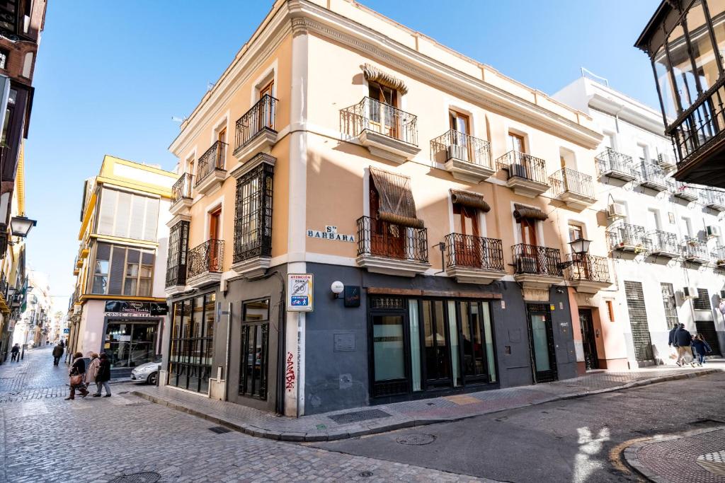 un edificio en una calle con gente caminando delante de él en Alameda Suites Apartments, en Sevilla
