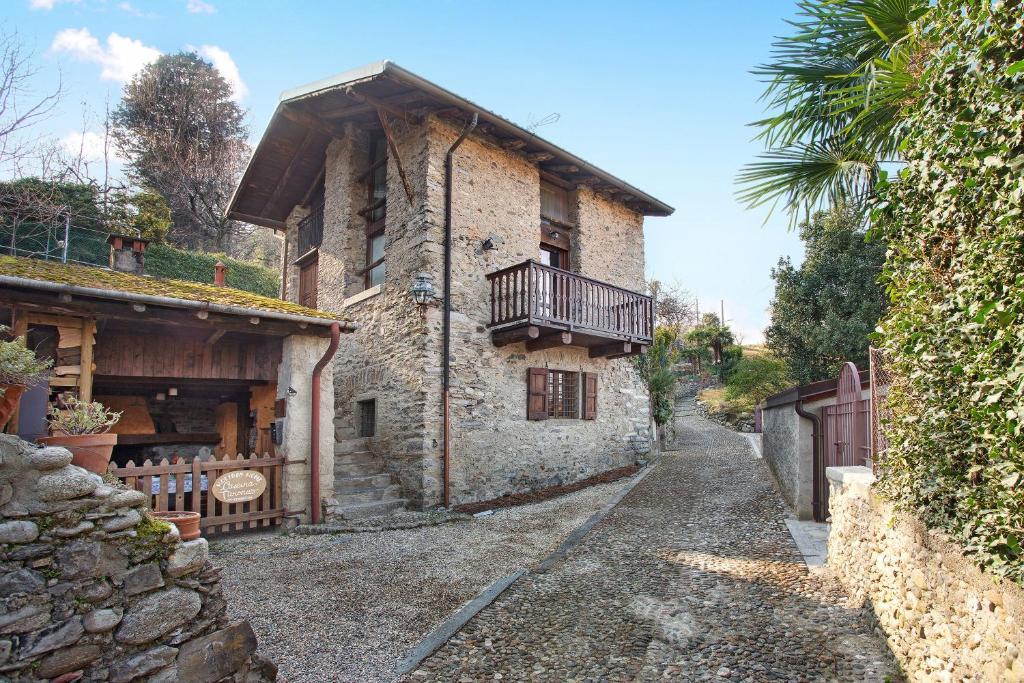a stone house with a balcony on a street at Cascina Taronico in Bellagio