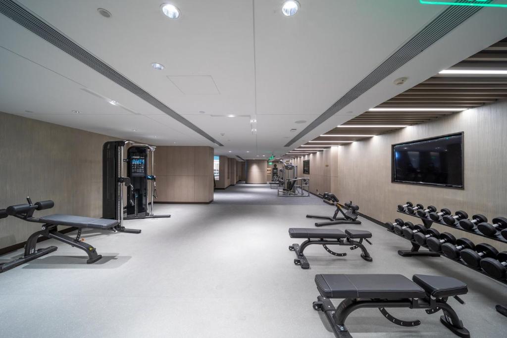 Un gimnasio con una fila de bancos y un televisor. en HUALUXE Xi'an Chanba by IHG-西安浐灞华邑酒店-Near Xi'an International Convention Exhibition Center and Shopping mall and The Romantic show of Xi'an-Free Luggage Storage-English Service, en Xi'an