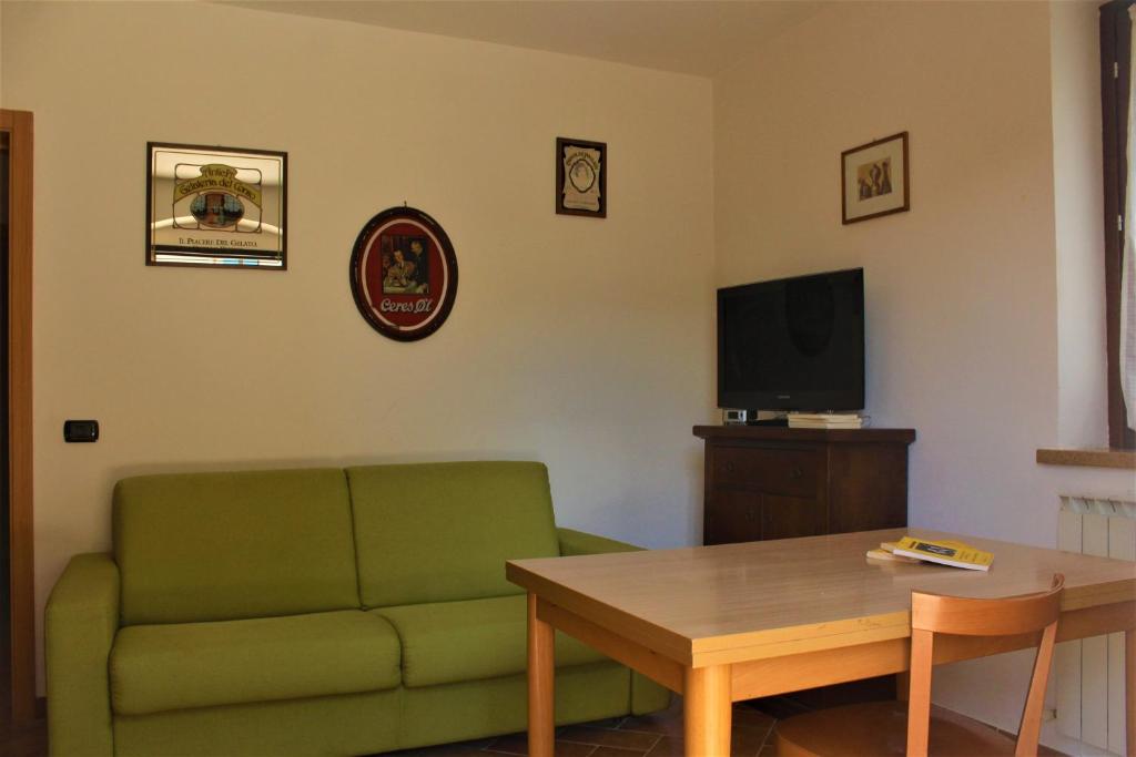 un soggiorno con divano verde e tavolo di Da Ginetto Assisi a Petrignano