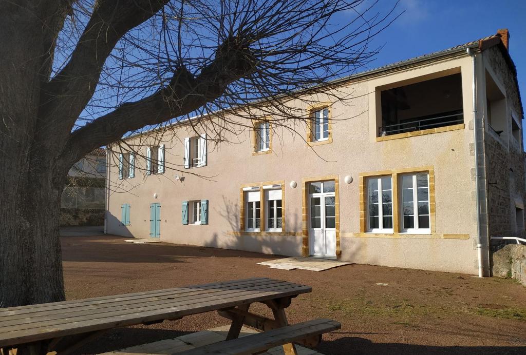 un edificio con un banco delante de él en Chambres d'Hôtes La Courlande, en Saint-Haon-le-Vieux