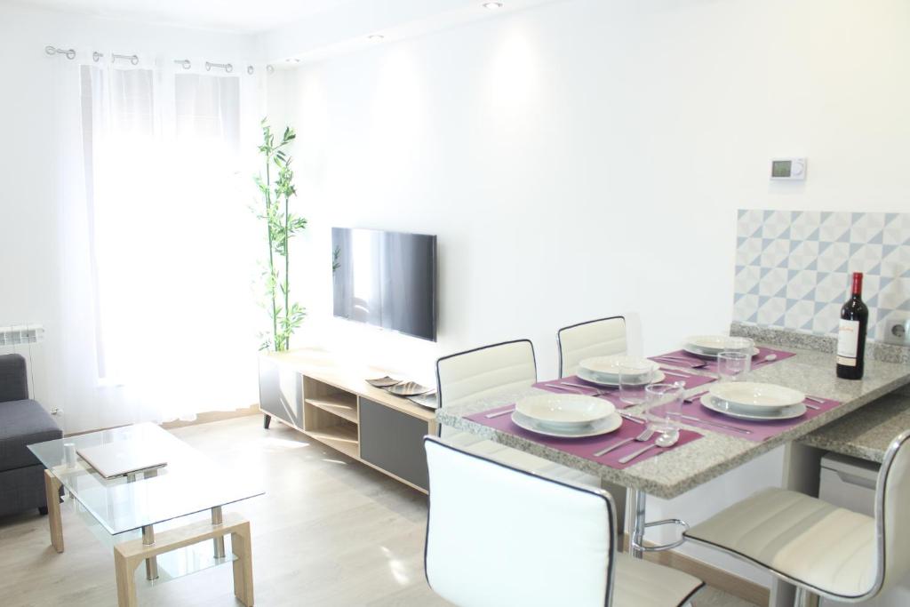 a dining room with a table and chairs and a tv at Alojamientos Centro Histórico de Ciudad Rodrigo in Ciudad-Rodrigo