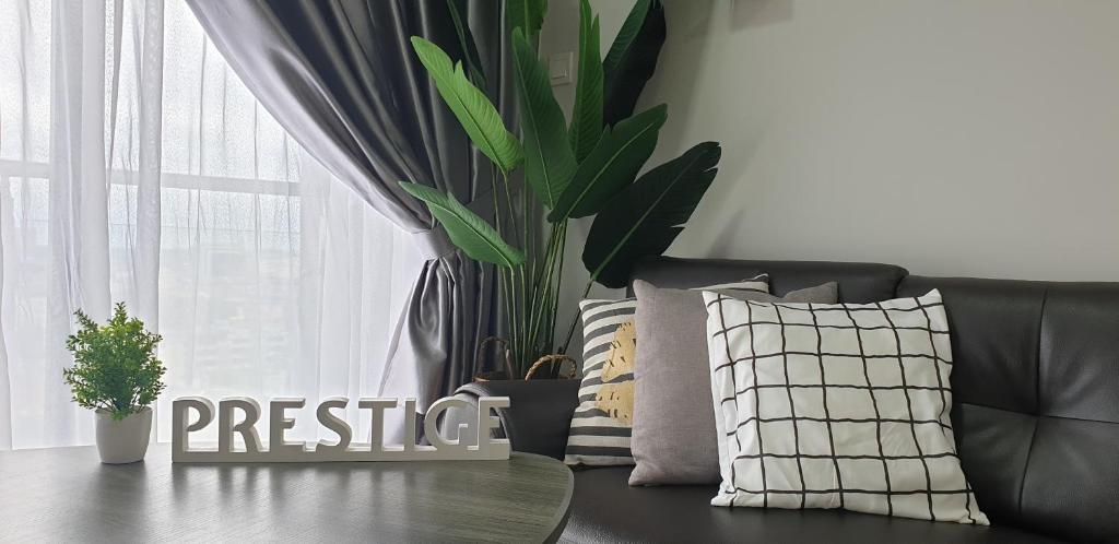 a couch with pillows and a plant next to a window at Prestige Sky Riverfront in Kota Bharu