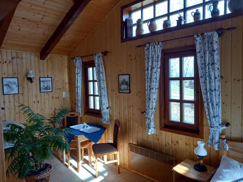 Pokój ze stołem i dwoma oknami w obiekcie Black Sheep Apartmant w mieście Lenti