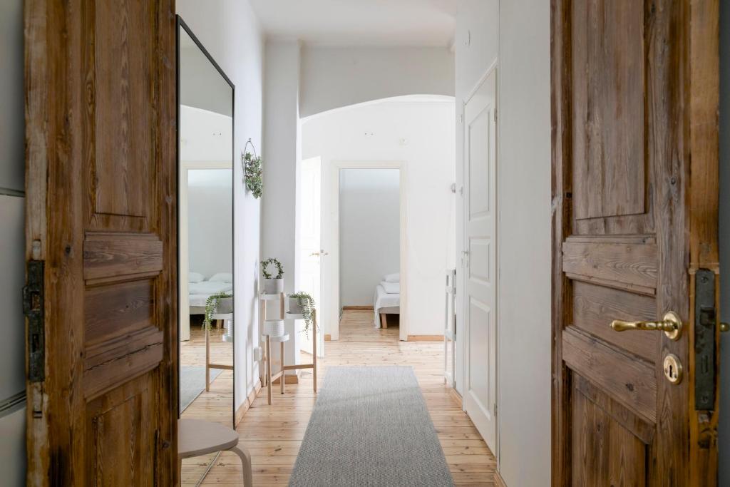 un couloir avec une porte ouverte et un miroir dans l'établissement 2ndhomes Central & Spacious 85m2 apartment in Yrjönkatu, à Helsinki